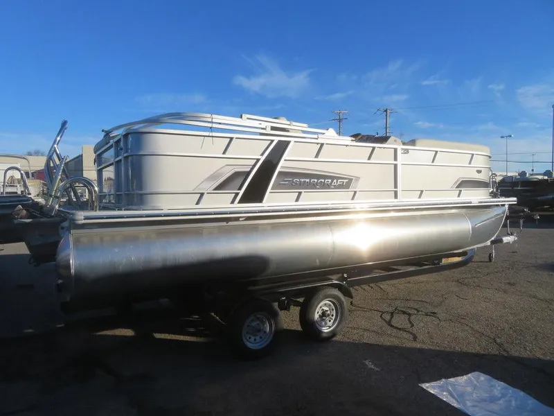 Slide: The Image of 2023 Starcraft EX 22 C pontoon boat on trailer under clear blue sky. - 3