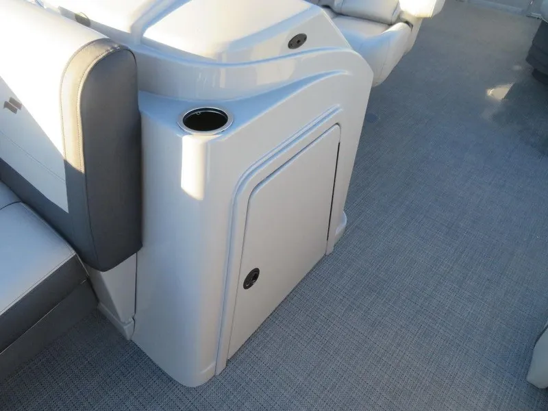 Slide: The Image of 2023 Starcraft EX 22 C boat interior with storage compartment and cup holder. - 6