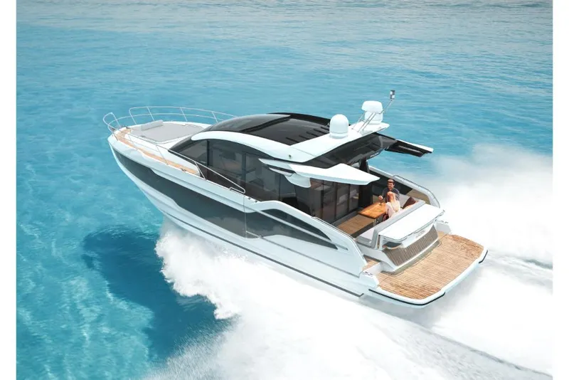 Slide: The Image of 2023 Galeon 450 HTC luxury yacht cruising on clear blue water. - 2