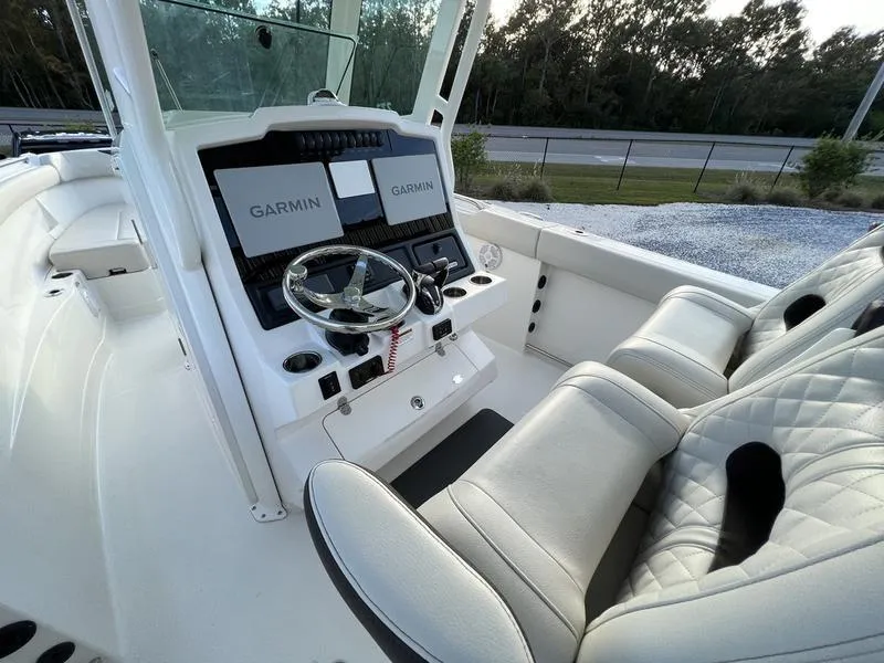 Slide: The Image of 2022 Sailfish 272 CC boat cockpit with Garmin navigation system and white leather seats. - 13