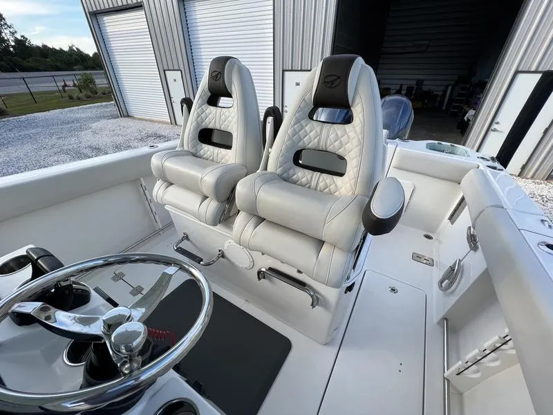 Slide: The Image of 2022 Sailfish 272 CC boat interior with dual captain's chairs and steering wheel. - 19