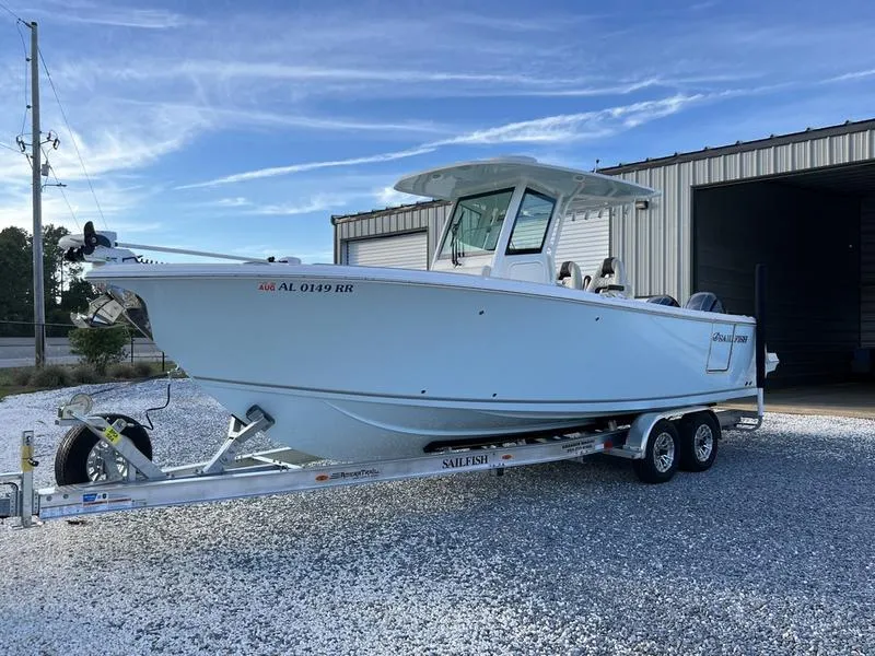 Slide: The Image of 2022 Sailfish 272 CC boat on a trailer outside a warehouse. - 2