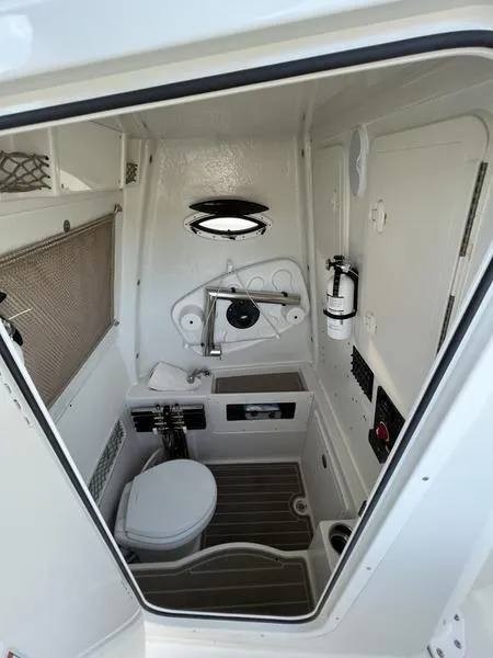 Slide: The Image of 2022 Sailfish 272 CC boat interior bathroom with toilet and sink. - 22