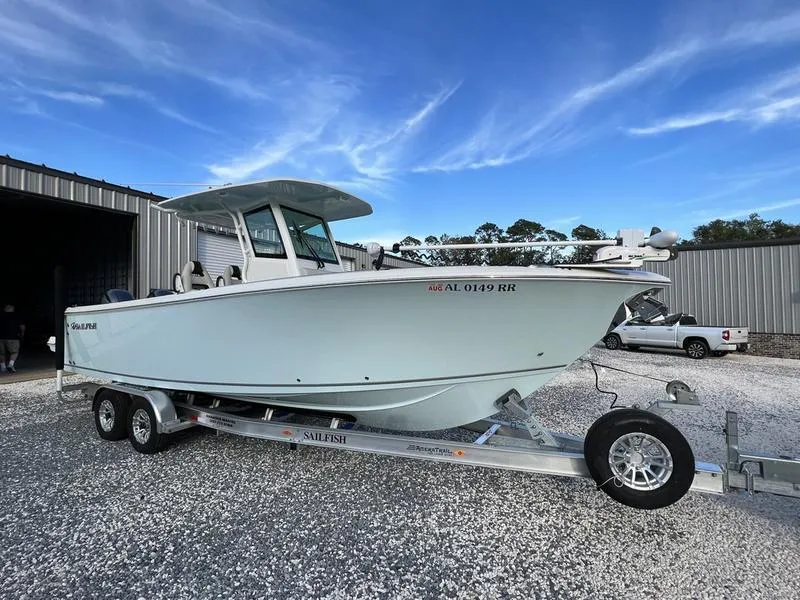Slide: The Image of 2022 Sailfish 272 CC boat on a trailer, parked outdoors near a metal building. - 4