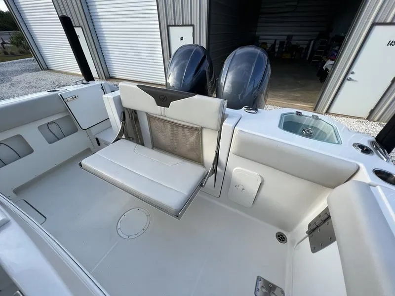 Slide: The Image of 2022 Sailfish 272 CC boat interior with fold-down seat and twin outboard motors. - 8