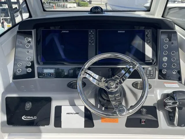 Slide: The Image of 2023 Robalo 266 Cayman boat dashboard with dual Simrad displays and Mercury controls. - 5