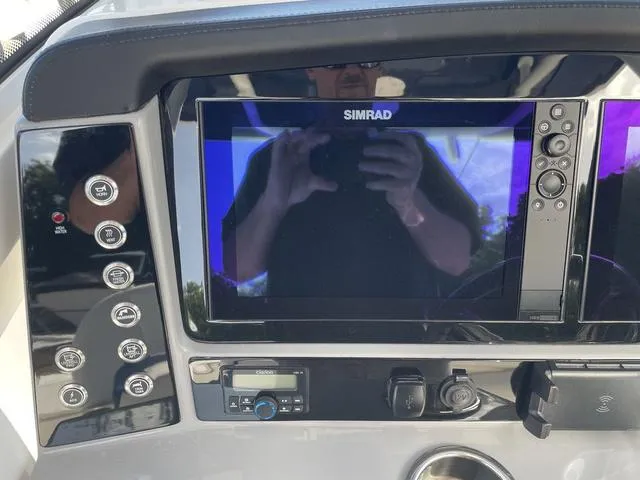 Slide: The Image of 2023 Robalo 266 Cayman boat dashboard with Simrad display and control buttons. - 7