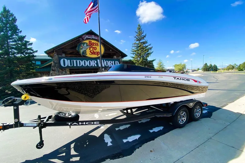 The Image of 2023 Tahoe 210 Si Limited boat on trailer outside Bass Pro Shop, clear sky. - 0