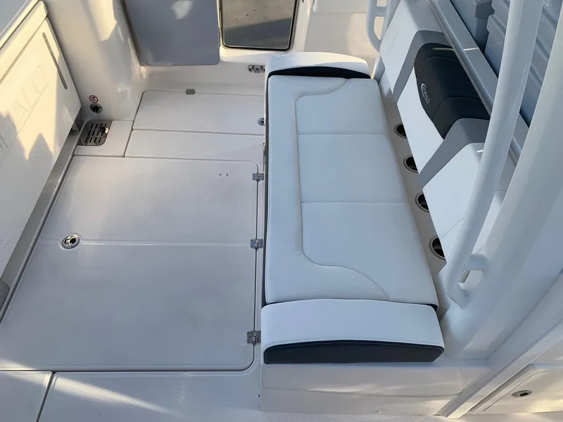Slide: The Image of 2024 Robalo R360 boat interior with white cushioned seating and storage compartments. - 19