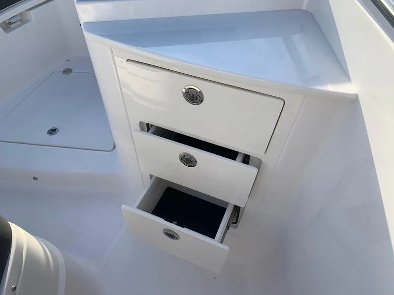 Slide: The Image of 2024 Robalo R360 boat interior with open storage drawers. - 26