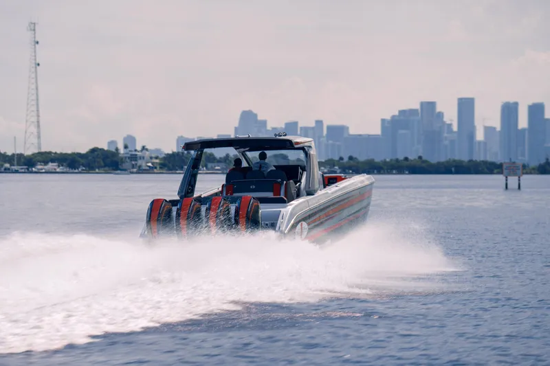 Slide: The Image of 2025 Cigarette 41 Nighthawk speedboat cruising on water with city skyline in background. - 3