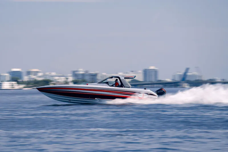Slide: The Image of 2025 Cigarette 41 Nighthawk speedboat cruising on water with city skyline in background. - 4