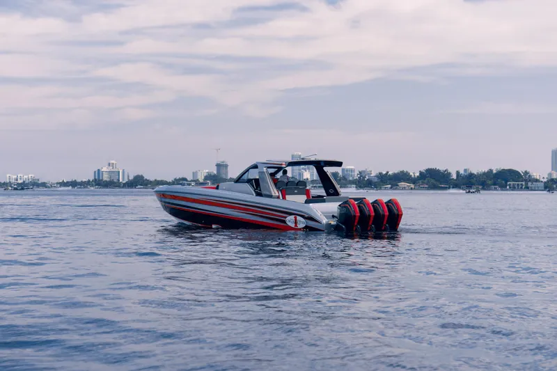 Slide: The Image of 2025 Cigarette 41 Nighthawk boat on calm water with city skyline in background. - 5