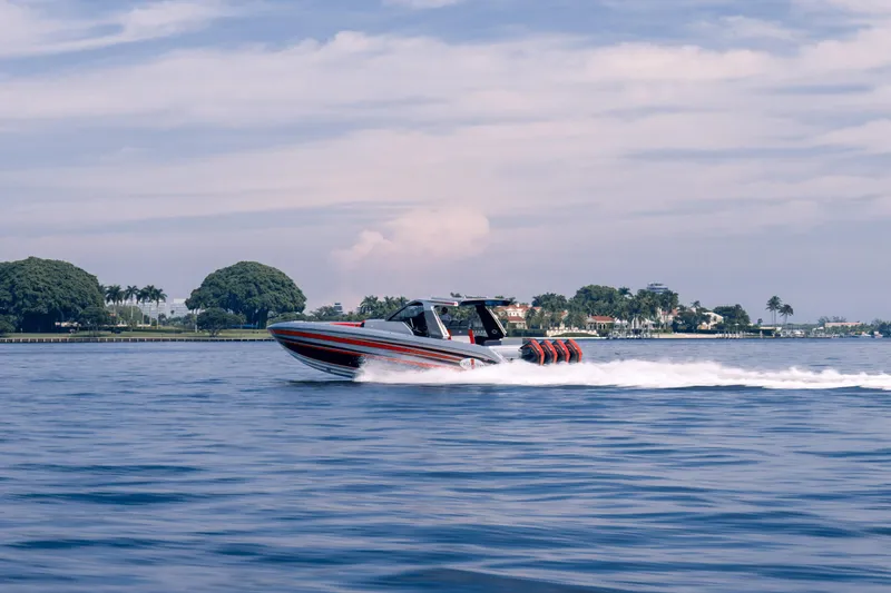 Slide: The Image of 2025 Cigarette 41 Nighthawk speedboat cruising on a calm blue sea near a coastal area. - 9