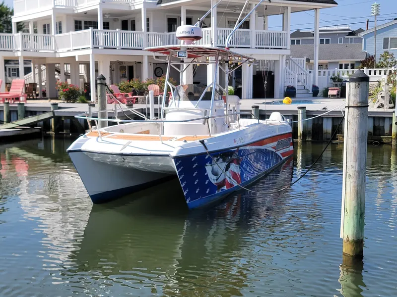 Slide: The Image of 1997 Glacier Bay 260 Canyon Runner boat docked near waterfront homes. - 3