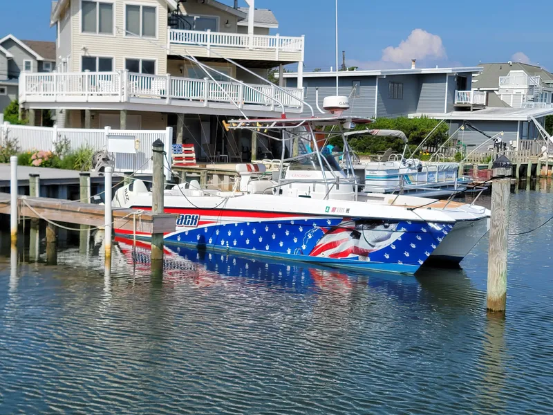 Slide: The Image of 1997 Glacier Bay 260 Canyon Runner boat docked near waterfront homes. - 4