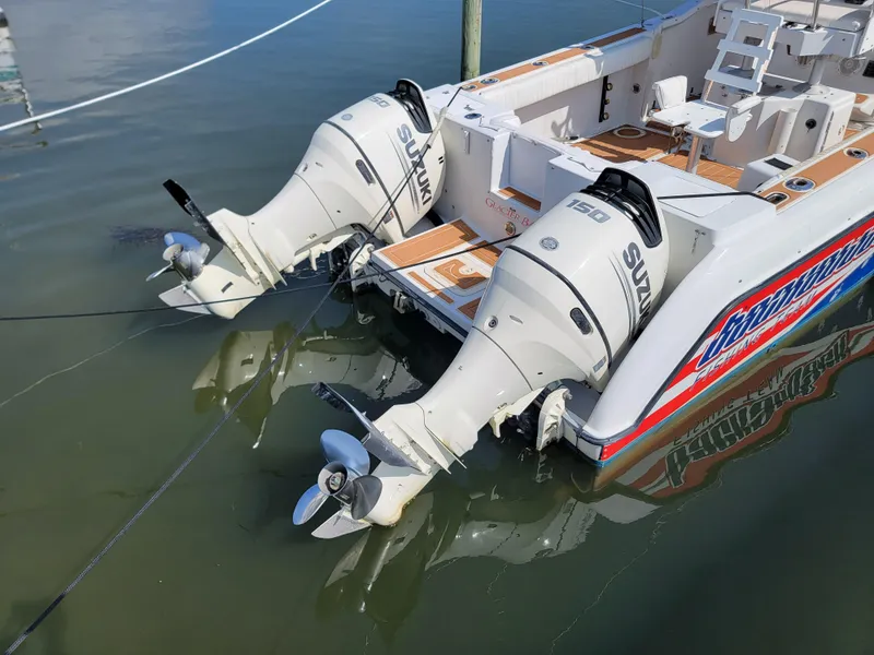 Slide: The Image of 1997 Glacier Bay 260 Canyon Runner with twin Suzuki outboard motors docked. - 6