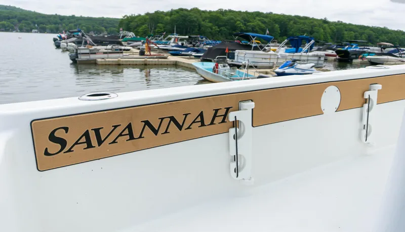 Slide: The Image of 2023 Savannah 220 IS boat docked at a marina with other boats in the background. - 11