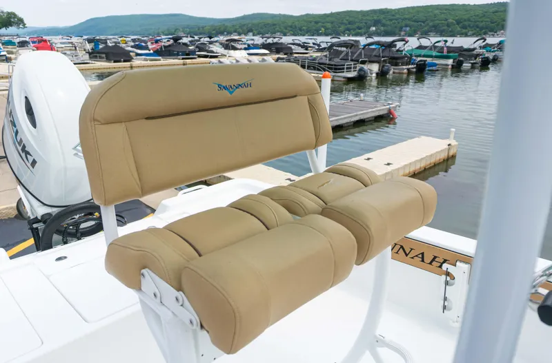 Slide: The Image of 2023 Savannah 220 IS boat with tan seating at a marina. - 7