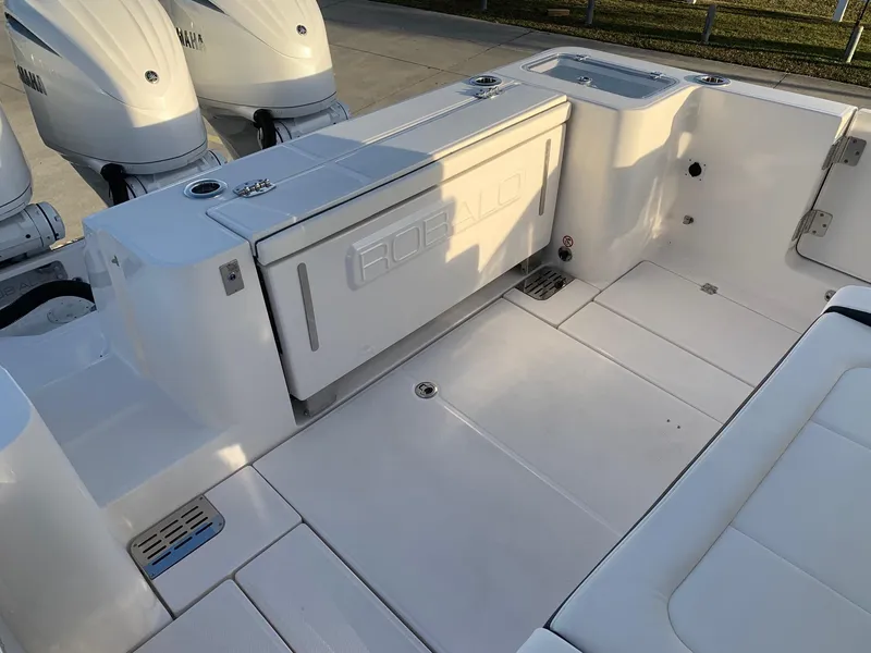 Slide: The Image of 2024 Robalo R360 boat deck with storage and triple outboard engines. - 8