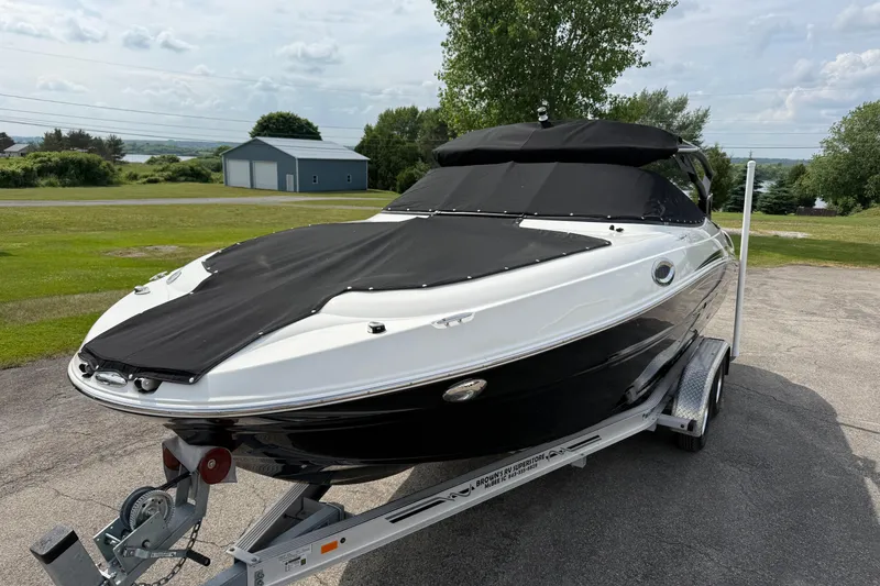 The Image of 2022 Stingray 235 LR boat on trailer, covered, parked outdoors. - 0