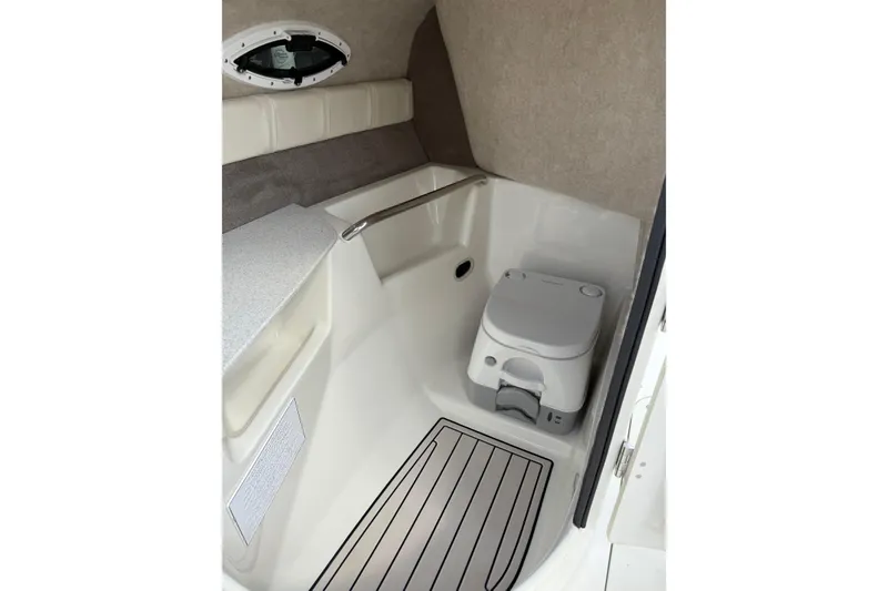 Slide: The Image of 2022 Stingray 235 LR boat interior with compact marine toilet and sleek design. - 11
