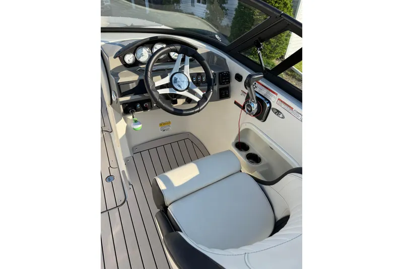 Slide: The Image of 2022 Stingray 235 LR boat interior with steering wheel and controls. - 12