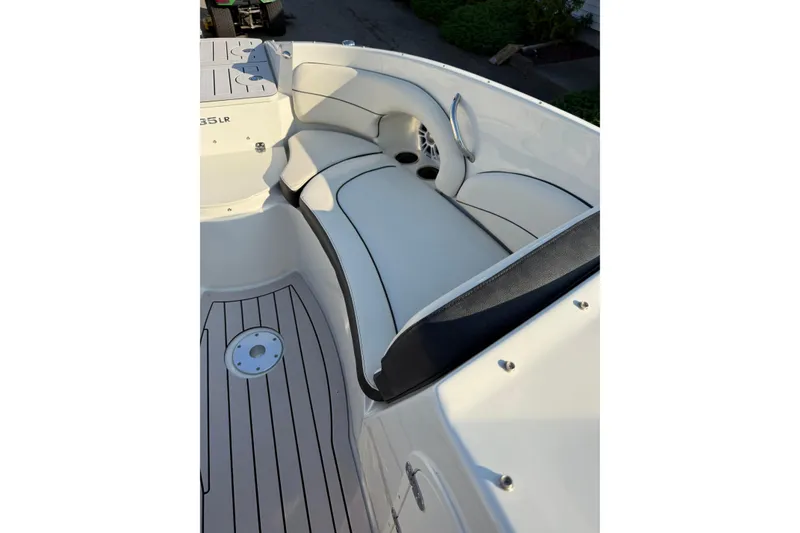 Slide: The Image of 2022 Stingray 235 LR boat interior with cushioned seating and sleek flooring. - 19