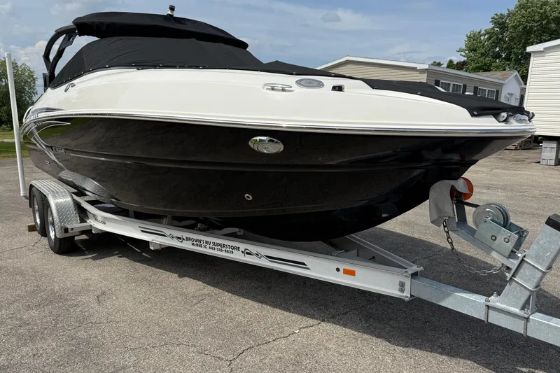 Slide: The Image of 2022 Stingray 235 LR boat on trailer, black and white design, parked outdoors. - 2