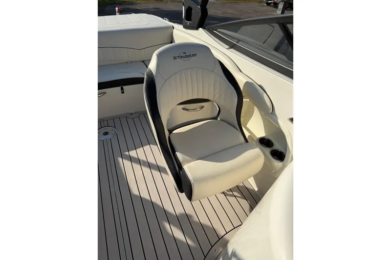 Slide: The Image of 2022 Stingray 235 LR boat interior with cushioned seating and cup holders. - 21