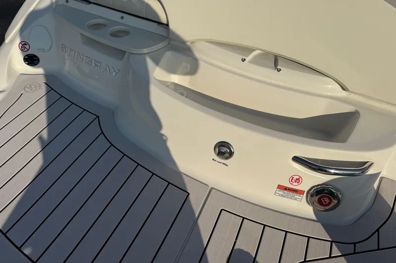 Slide: The Image of 2022 Stingray 235 LR boat deck with cup holders and safety warnings. - 22