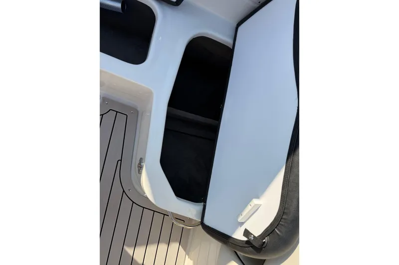 Slide: The Image of 2022 Stingray 235 LR boat interior storage compartment with sleek design and flooring. - 26