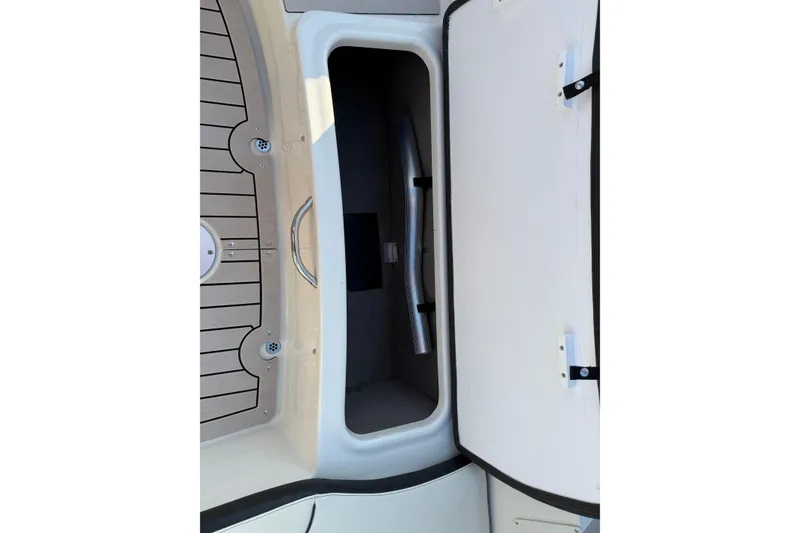 Slide: The Image of Open storage compartment in 2022 Stingray 235 LR boat, featuring sleek interior design. - 27