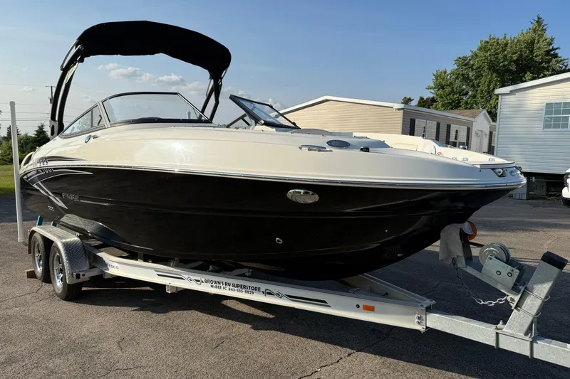 Slide: The Image of 2022 Stingray 235 LR boat on trailer, black and white design, parked outdoors. - 28