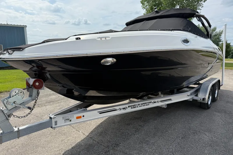 Slide: The Image of 2022 Stingray 235 LR boat on trailer, black and white exterior, parked outdoors. - 3