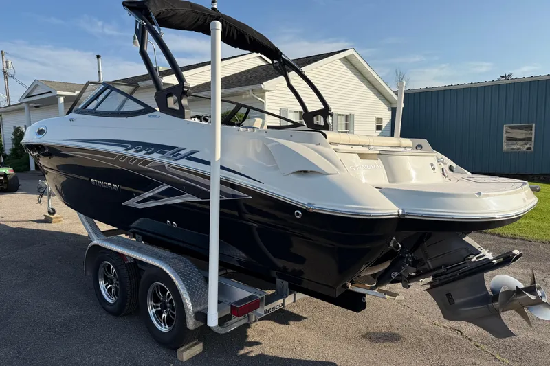 Slide: The Image of 2022 Stingray 235 LR boat on trailer, parked outdoors near buildings. - 30