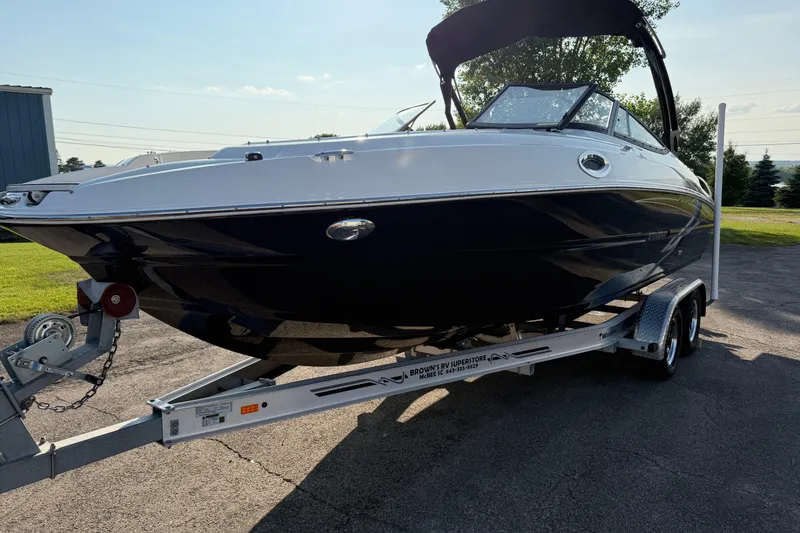 Slide: The Image of 2022 Stingray 235 LR boat on trailer, parked outdoors, under sunny sky. - 31