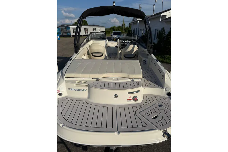 Slide: The Image of 2022 Stingray 235 LR boat with spacious deck and seating, docked outdoors. - 32