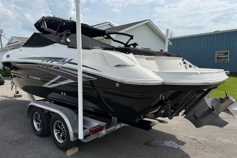 Slide: The Image of 2022 Stingray 235 LR boat on trailer, black and white design, parked outdoors. - 4