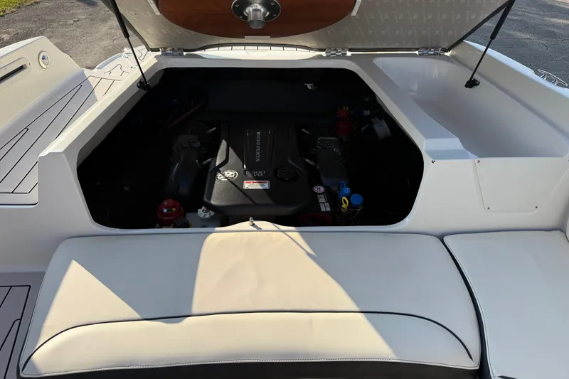 Slide: The Image of 2022 Stingray 235 LR boat engine compartment with open hatch, showcasing interior components. - 9