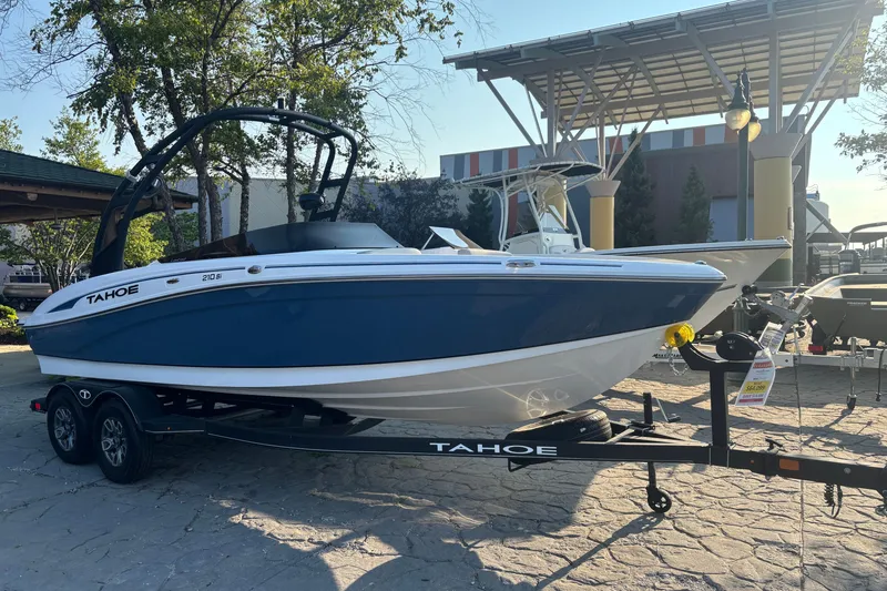 The Image of 2023 Tahoe 210 Si Limited boat on trailer, displayed outdoors in a marina setting. - 0