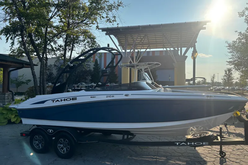 Slide: The Image of 2023 Tahoe 210 Si Limited boat on trailer, parked outdoors in sunlight. - 1