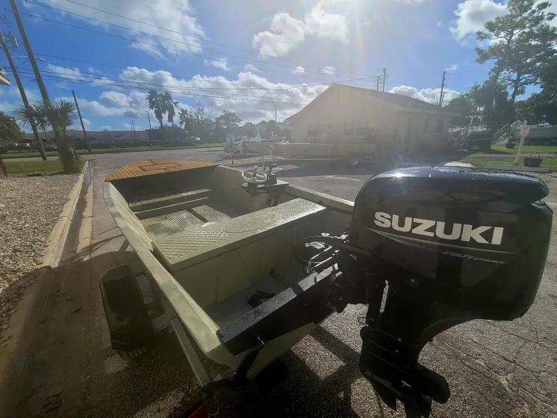 Slide: The Image of 2021 Hog Island Boat Works SW16 with Suzuki outboard motor in a sunny outdoor setting. - 6