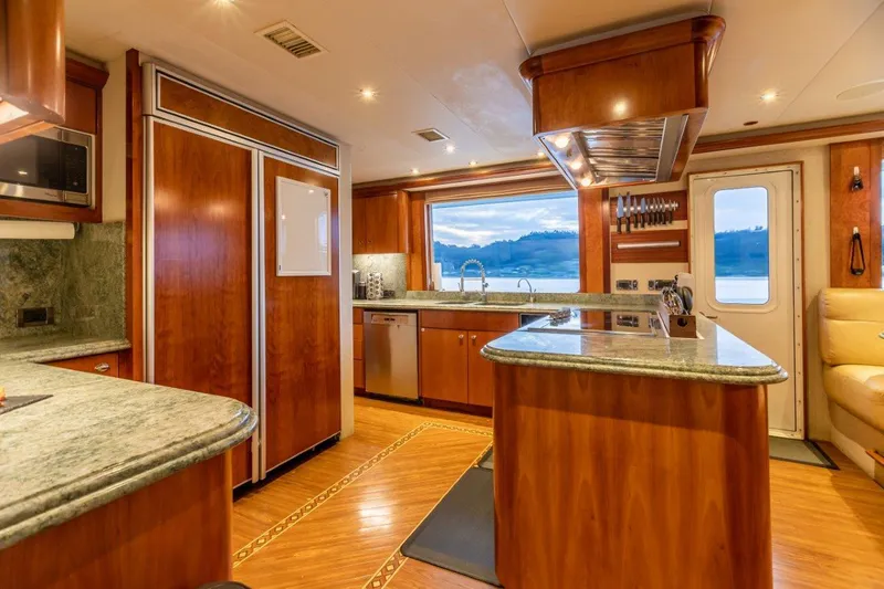 Slide: The Image of Luxurious kitchen interior of a 2002 Westport Flybridge yacht with modern appliances and wood finishes. - 11