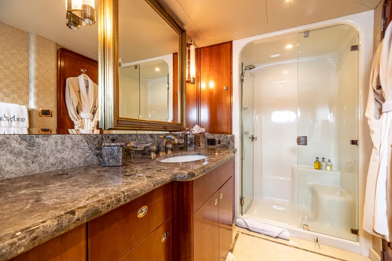 Slide: The Image of Luxurious bathroom on a 2002 Westport Flybridge yacht with marble countertop and glass shower. - 26