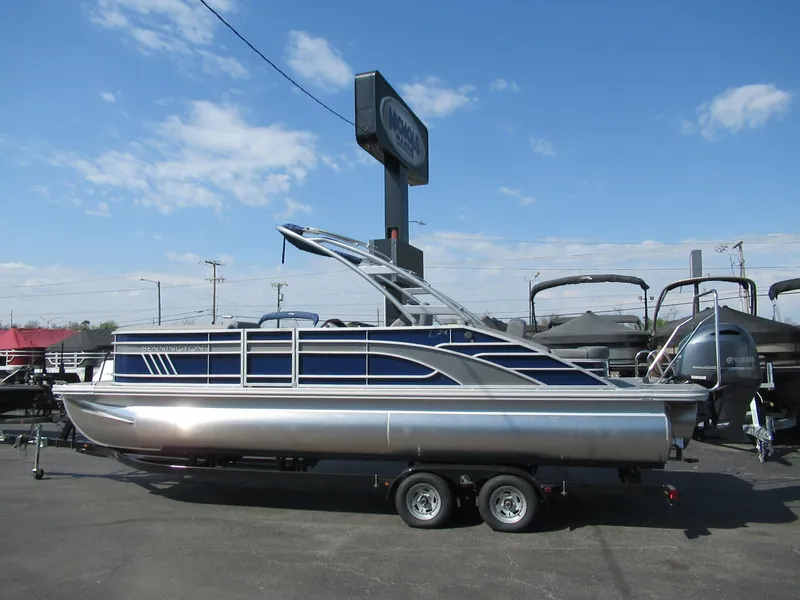 Slide: The Image of 2023 Bennington 24 LSBA pontoon boat on a trailer in a dealership lot. - 0