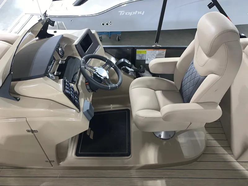 Slide: The Image of 2024 Starcraft SLS 3 DC boat cockpit with beige captain's chair and steering wheel. - 7