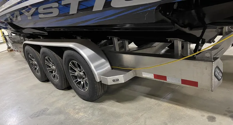 Slide: The Image of Mystic 3800 boat on a triple-axle trailer, 2020 model, in a garage. - 10