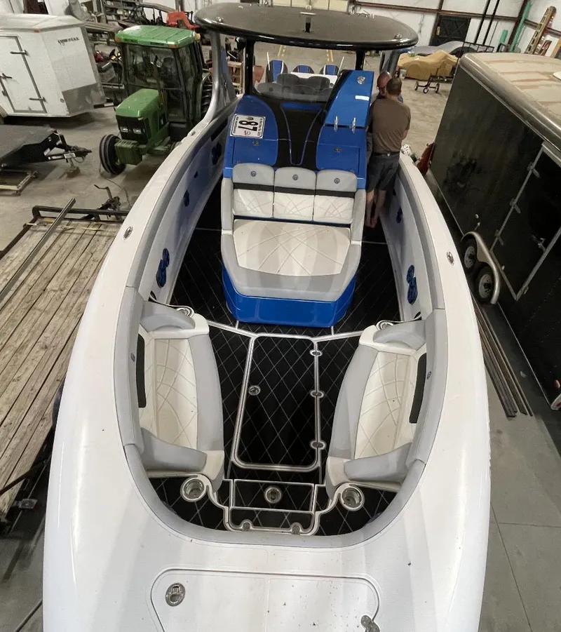 Slide: The Image of 2020 Mystic 3800 boat interior with white and blue seating in a storage facility. - 23