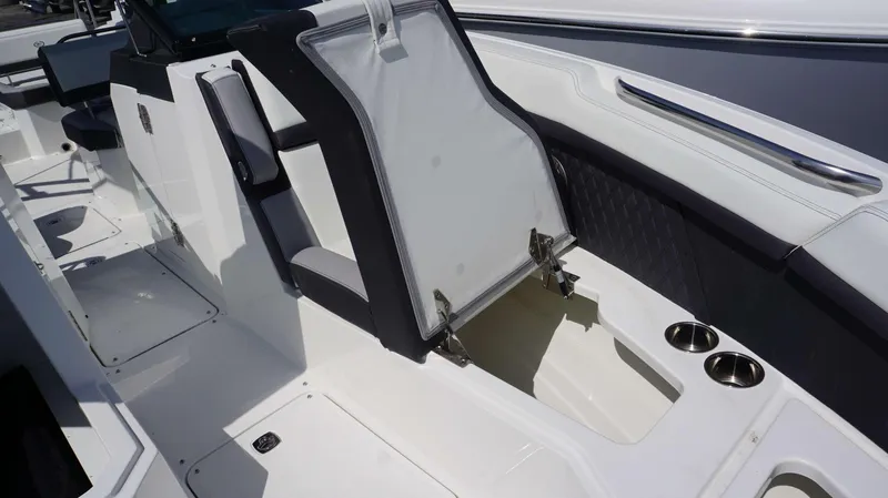 Slide: The Image of 2023 Cobalt R8 boat interior with open storage compartment and cup holders. - 18